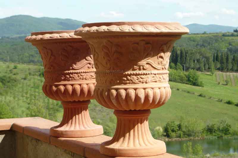 Verzierte Terracotta-Pokale vor toskanischer Landschaft